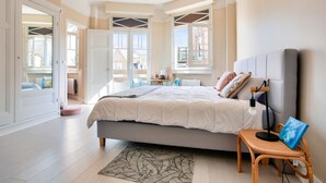 Un dormitorio con cama, mesita de noche y vistas al exterior.
