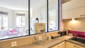 Una cocina moderna con un ventanal grande, una cesta colgante, un tostador y un lavabo.