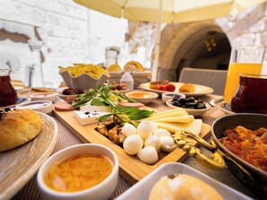 A breakfast spread with various cheeses, nuts, and bread on a wooden board. - Ares Cave Suites (Nevsehir)