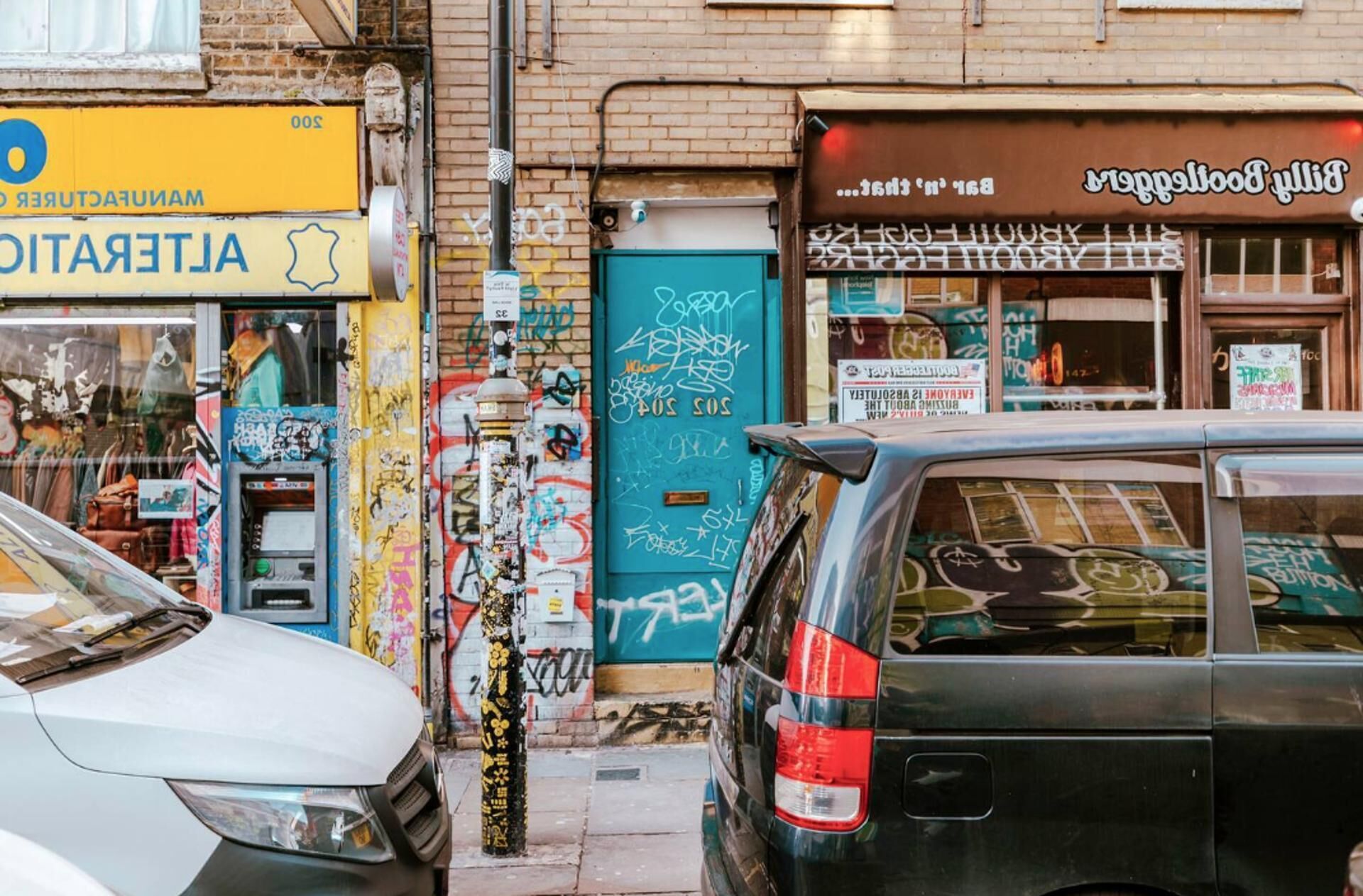 A street with a blue door, a yellow sign, and a brown awning.
