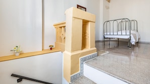 Ein Zimmer mit einem Bett, einem kleinen Altar und einem Regal mit Blumen.