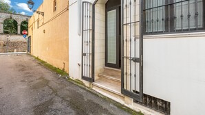 Ein Gebäude mit weißer Fassade, einem schwarzen Metallgitter und einem Stoppschild.