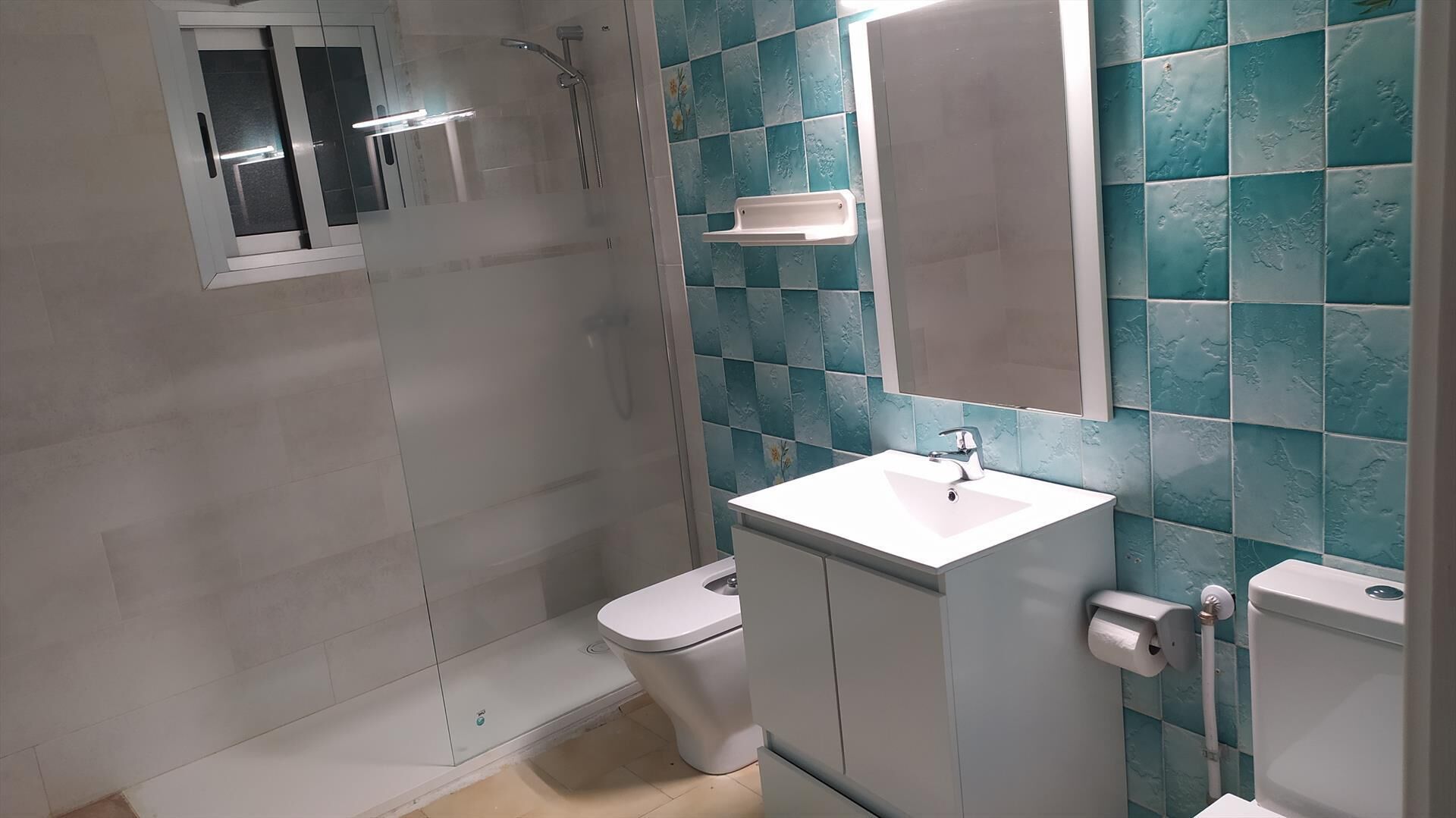 Un baño con ducha, inodoro y lavabo.