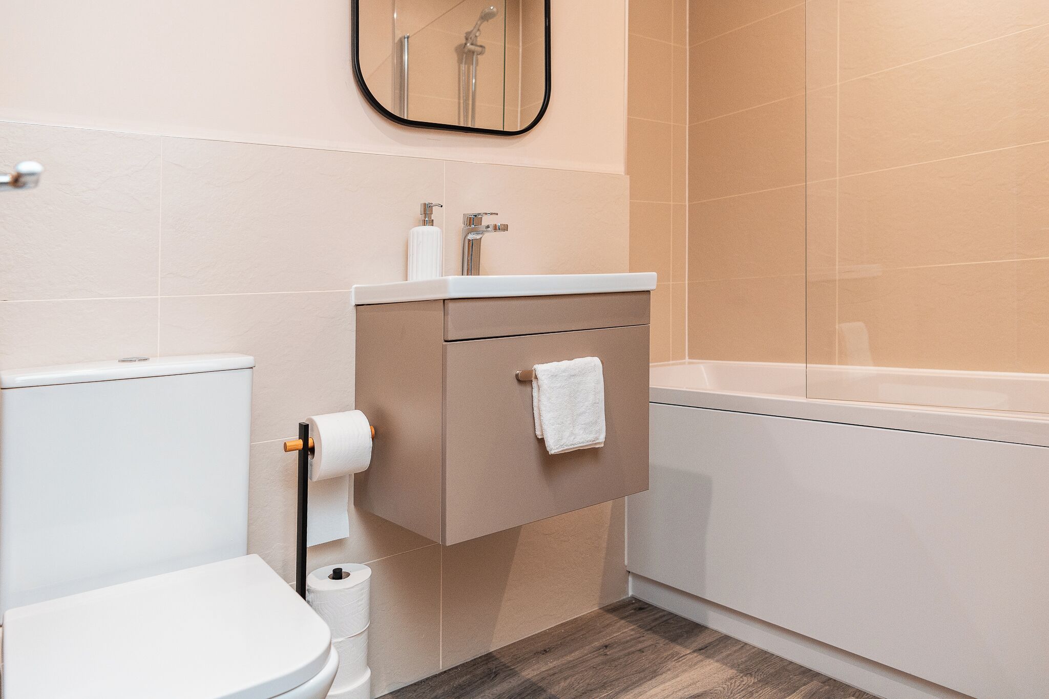 Un baño moderno con inodoro, lavamanos y bañera.