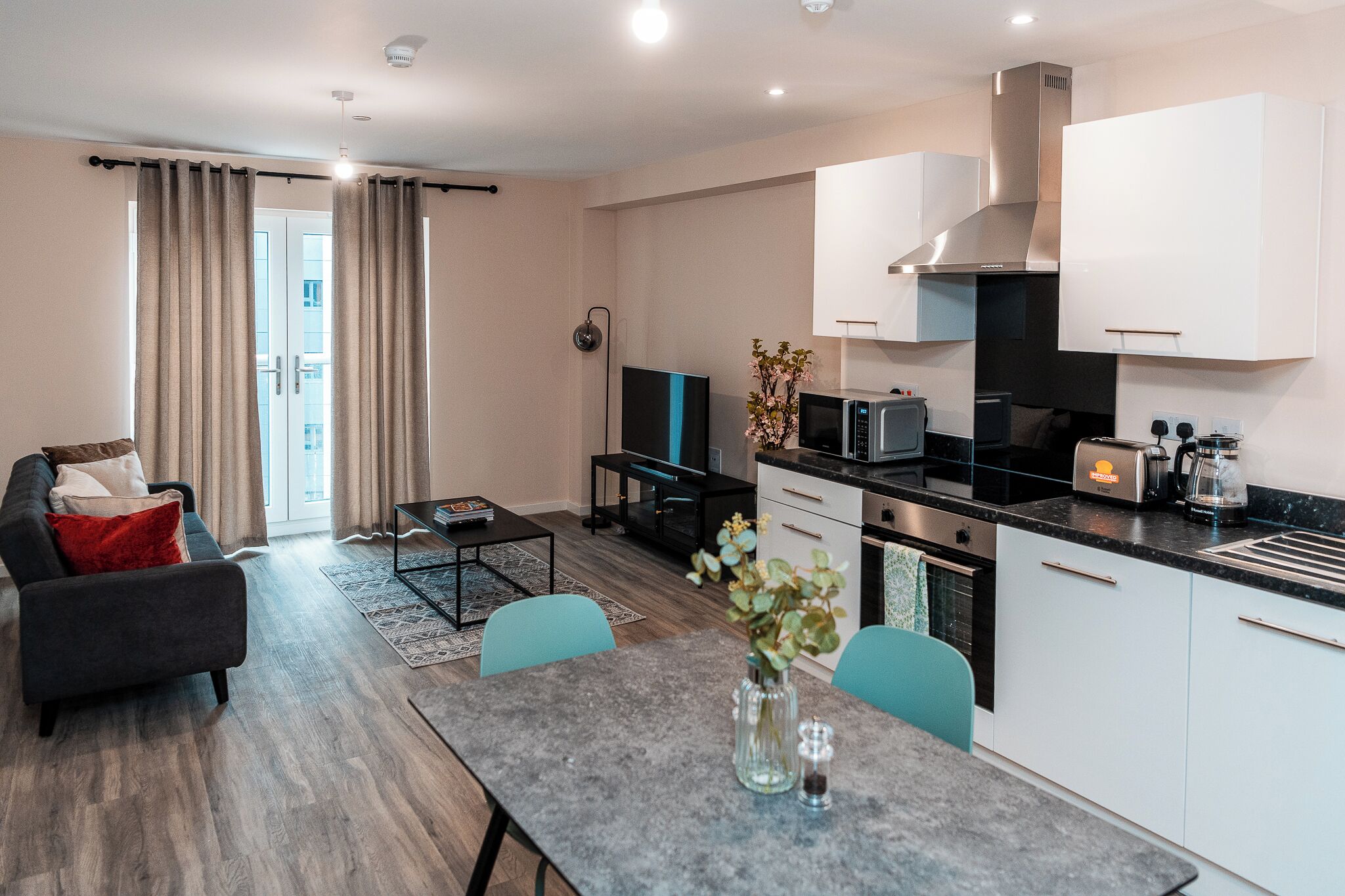 A modern apartment with a living room, dining area, and kitchen.
