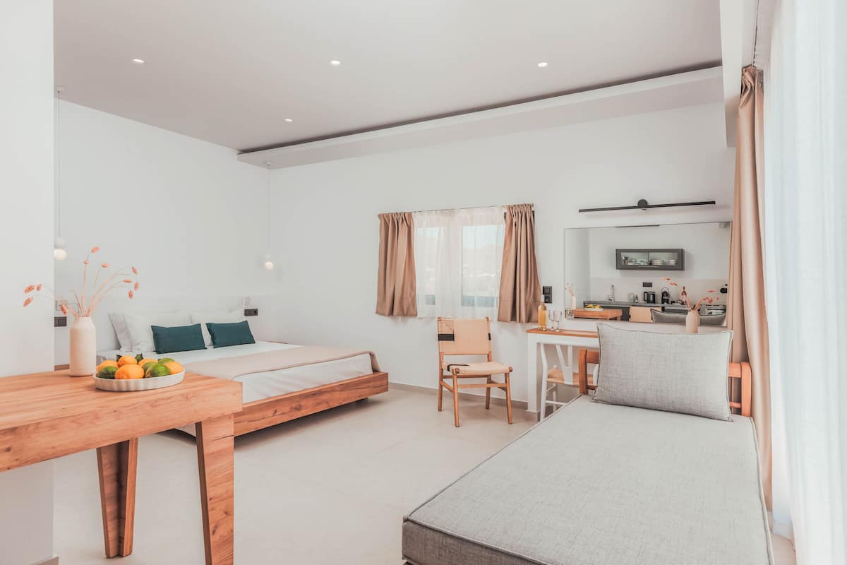 Een moderne hotelkamer met een bed, een bureau en een kitchenette.