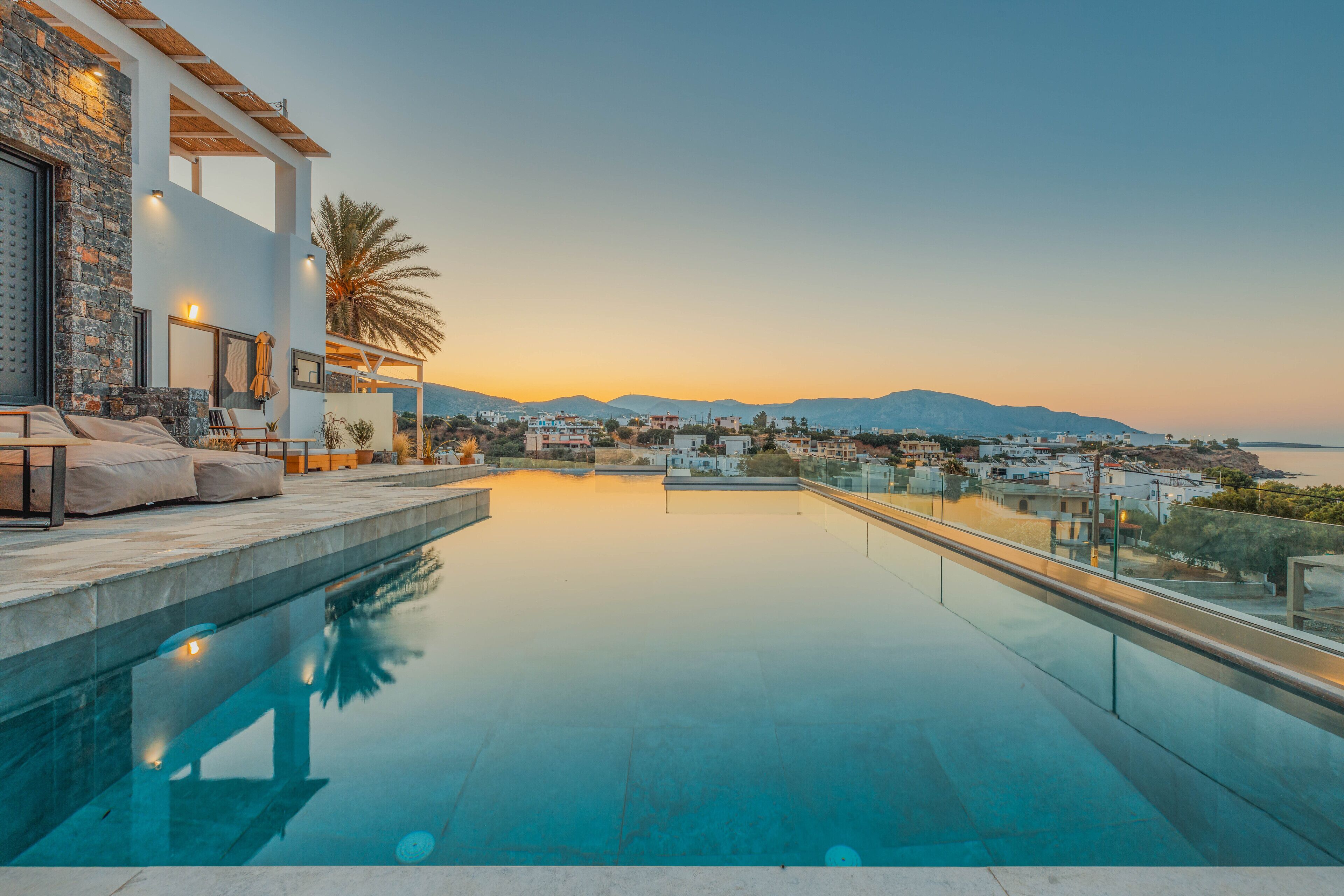 Un área de piscina moderna con vistas despejadas del paisaje circundante y montañas distantes.