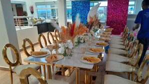 A long dining table with gold chairs, set with white tablecloths, gold napkins, and floral centerpieces. - equine hotel ruiru nairobi (Ruiru)