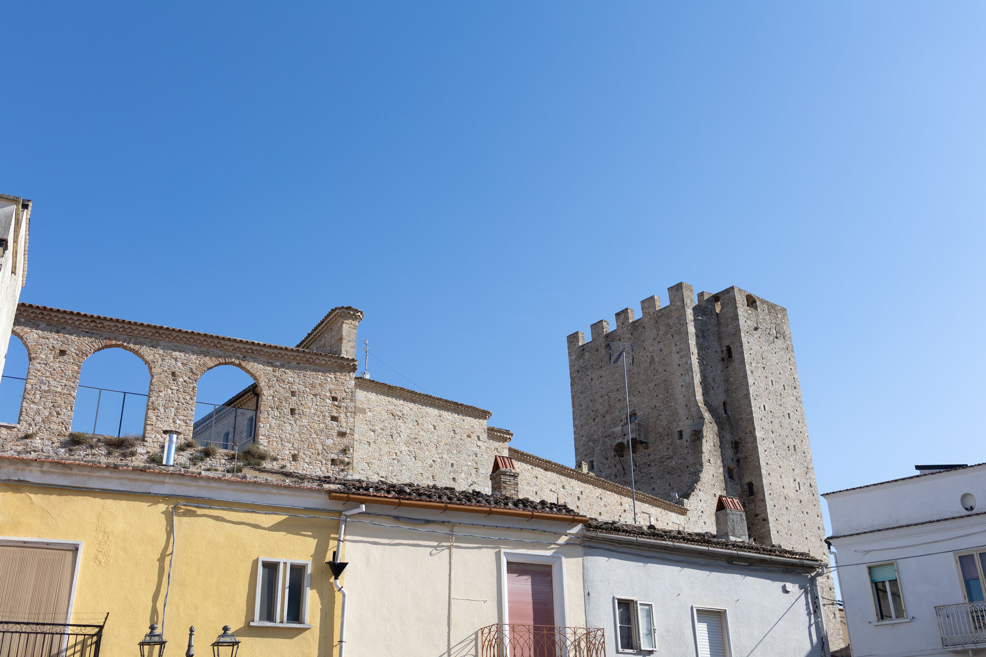 Un edificio histórico con una torre y ventanas de arco.