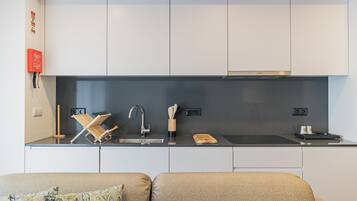 A modern kitchen with white cabinets, a black countertop, and a Bosch range hood.