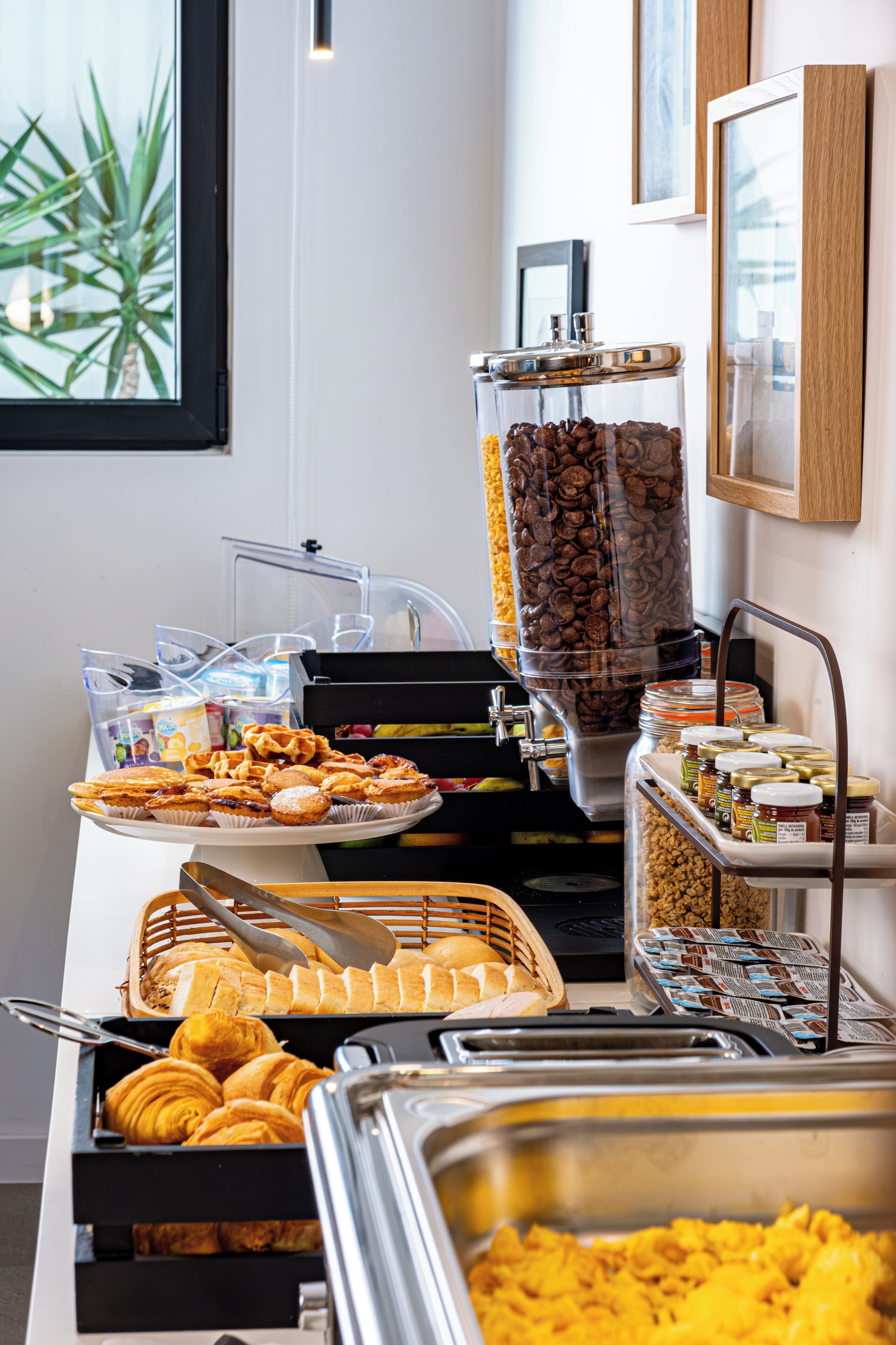Un buffet con diversi cibi tra cui pasticceria, panini e una macchina per il caffè.