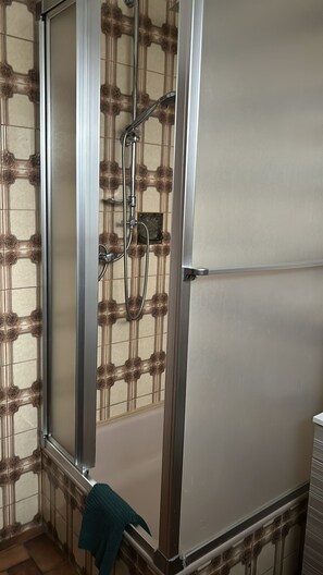 Regadera, secadora de cabello, papel de baño 