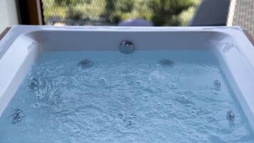 Una bañera de hidromasaje con burbujas visibles, mostrando que está llena de agua.