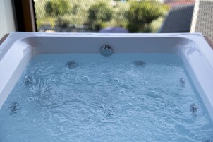 Una bañera de hidromasaje con burbujas visibles, mostrando que está llena de agua.