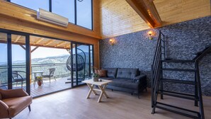 A spacious room with a balcony, a sofa, a table, and a ladder. - La Veranda Villas (Kumluca)
