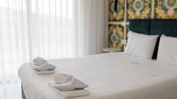 A hotel room with a neatly made bed, white linens, and a headboard with a patterned design.