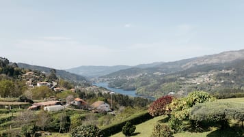 Vista panorámica de un valle con un lago, rodeado de colinas y casas.