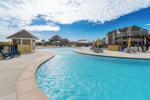 A swimming pool with lounge chairs and a lifeguard tower.