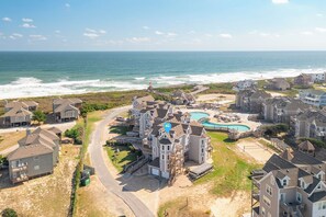 Un quartier résidentiel situé sur la côte, avec des maisons, une piscine et une jetée.