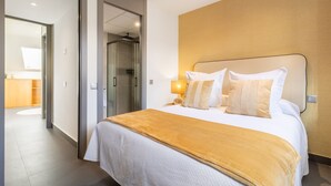 A hotel room with a bed, a bedside lamp, and a wooden headboard. - Amazing new duplex for 4 (Madrid)