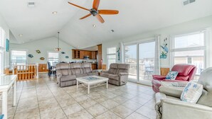 A spacious living room with a ceiling fan, a dining area, and a kitchen.