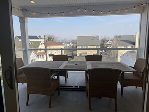 Relax in this serene outdoor seating area with a table and four chairs, surrounded by a covered space with a view of the city.