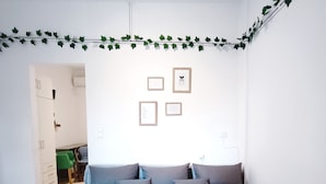 Une chambre à coucher avec un lit, un bureau et une chaise. Il y a quatre tableaux encadrés accrochés au mur.