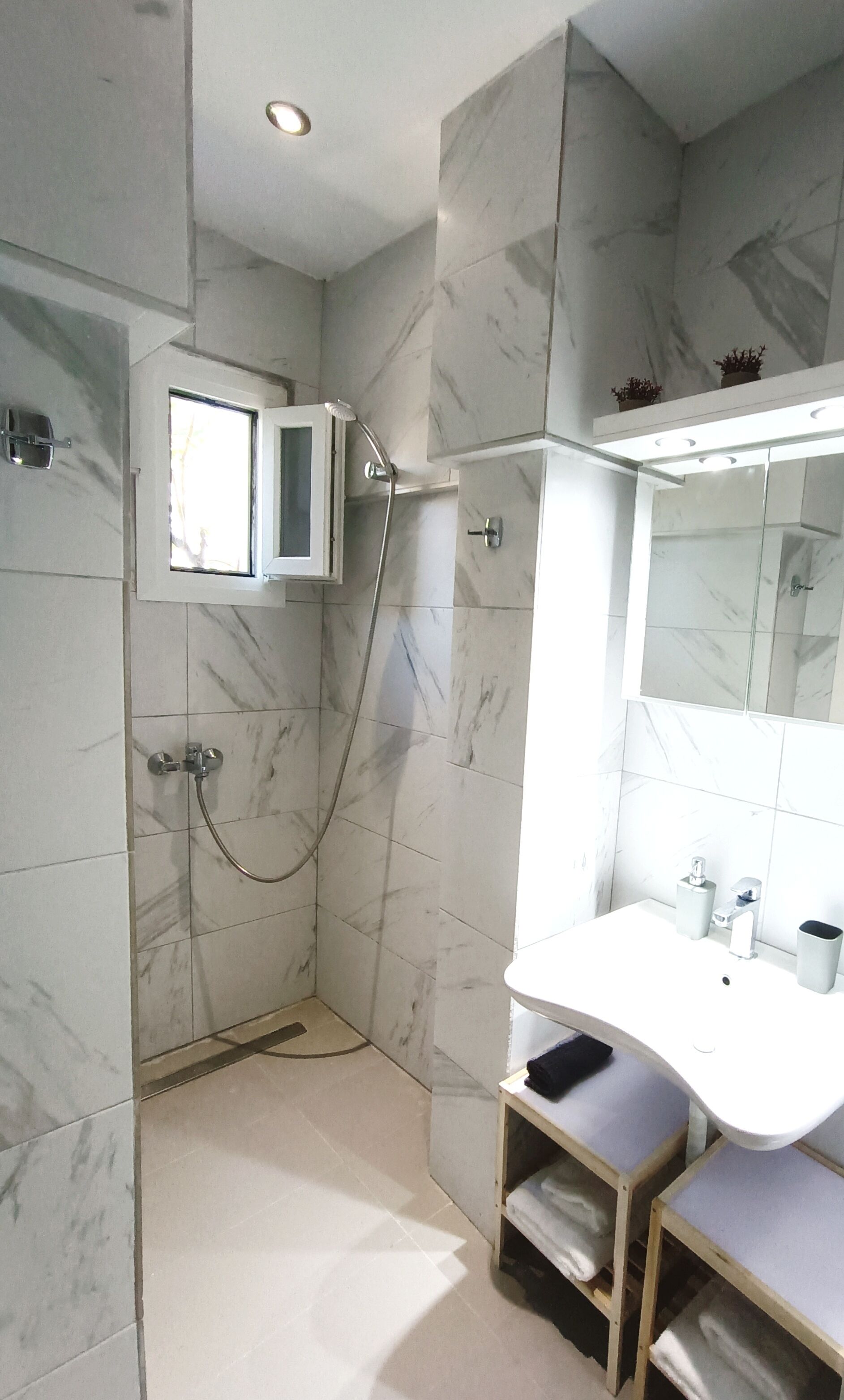 A modern bathroom with a shower, a sink, and a mirror.
