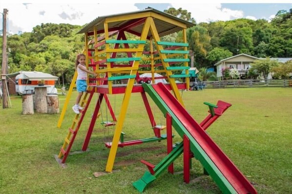 A playground with a climbing structure and slides.
