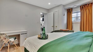 A bedroom with a bed, a desk, and a wardrobe.