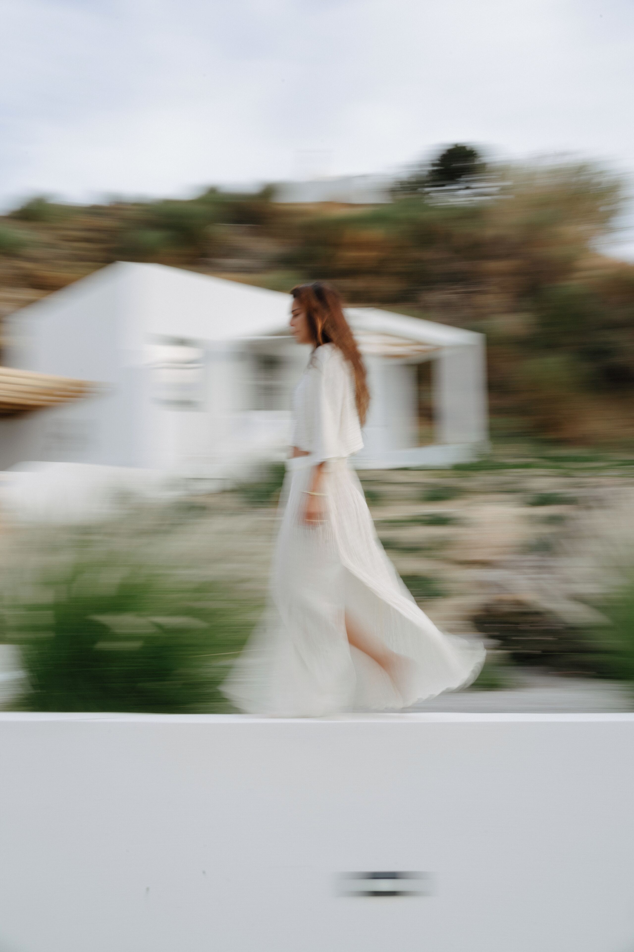 A person in a white dress walking on a white structure.