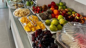 A buffet with various fruits, cheeses, and condiments. - Pousada Villa Minduba (Japaratinga)