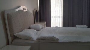 A neatly made bed with a headboard, a bedside table, and a nightstand. - vbasuıten (Istanbul)