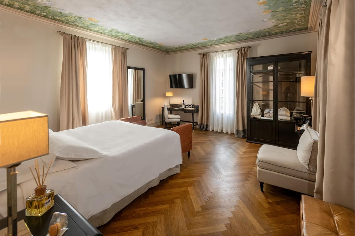 Une chambre d’hôtel avec un grand lit, un bureau, une télévision et un coin salon.