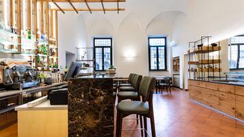Un bar moderne avec des comptoirs en marbre, des étagères en bois et des tabourets de bar.