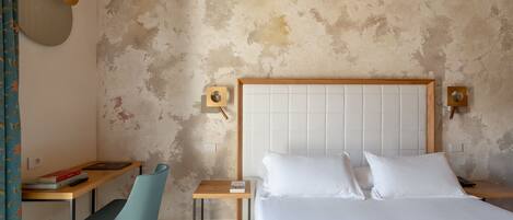A bedroom with a bed, bedside tables, a desk, and a chair.