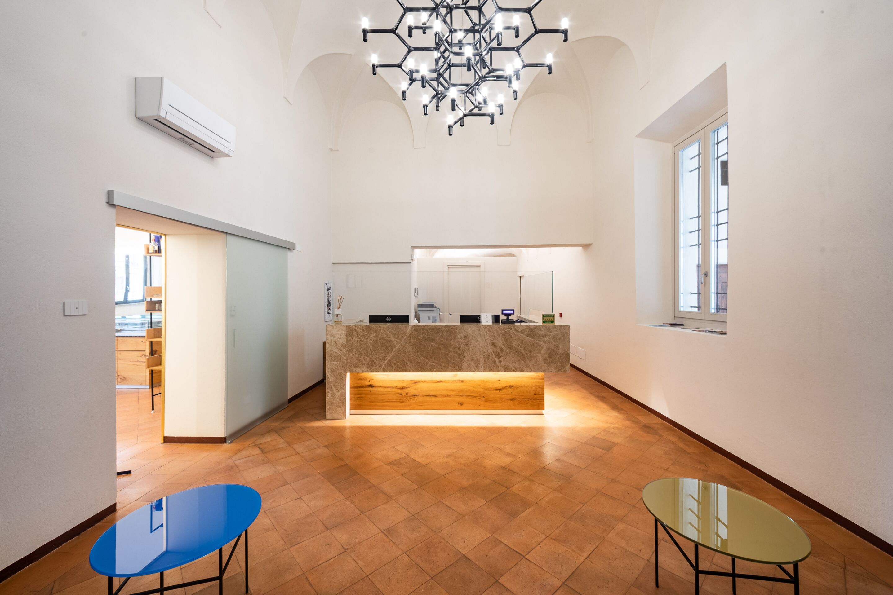 Ein modernes Interieur mit einer Rezeption, einer Kristallleuchtre und Holzboden.