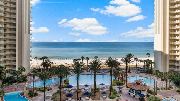 Ein Resort mit Pool, Blick auf den Strand und mehreren Balkonebenen.