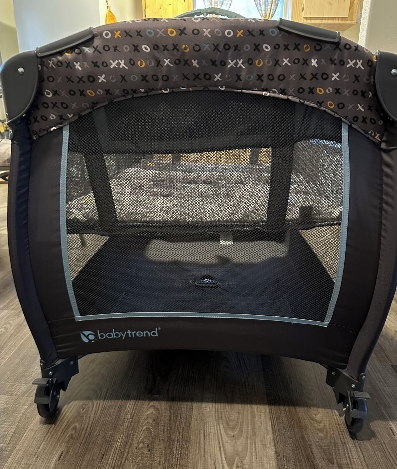 Um mini trampolim para bebê com proteção de tela e parte superior estampada.