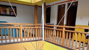 Un intérieur à plusieurs niveaux, doté d’un escalier central, de rampes en bois et d’une sculpture suspendue.