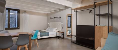 Una habitación moderna y bien iluminada con una cama, un escritorio y una zona de estar.