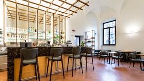 A bar area with a wooden ceiling, bar stools, and shelves with bottles. - Bonacolsi Collection , Mantegna Hotels (Mantua)