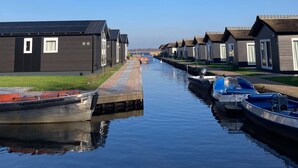 Un canal con casas adosadas en un lado y barcos amarrados en el otro.