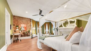 Un dormitorio con cama a dosel, un escritorio y una pared de ladrillo.