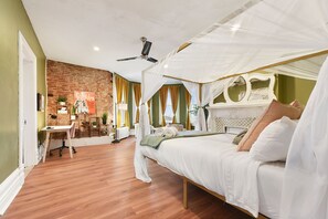 Une chambre à coucher avec un lit à baldaquin, un bureau et un mur en briques.
