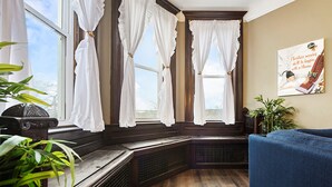 Una habitación con un banco de madera, un sofá azul y un radiador.