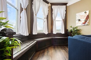 Une pièce avec un banc en bois, un canapé bleu et un radiateur.