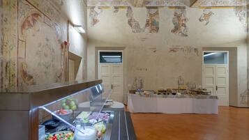 Un espace buffet proposant une grande variété de plats, un mur en marbre orné de fresques décoratives et un plafond au design classique.