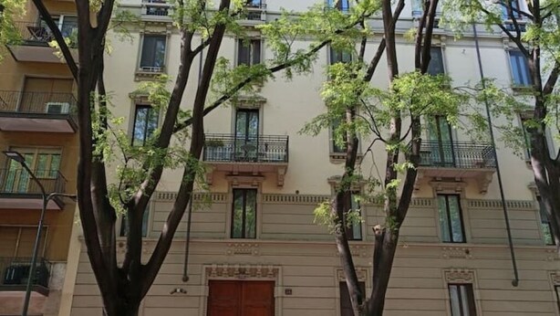 A multi-story building with balconies, a large central door, and trees in front. - Welcome Studio 36, 15 minutes to Duomo (Milano)
