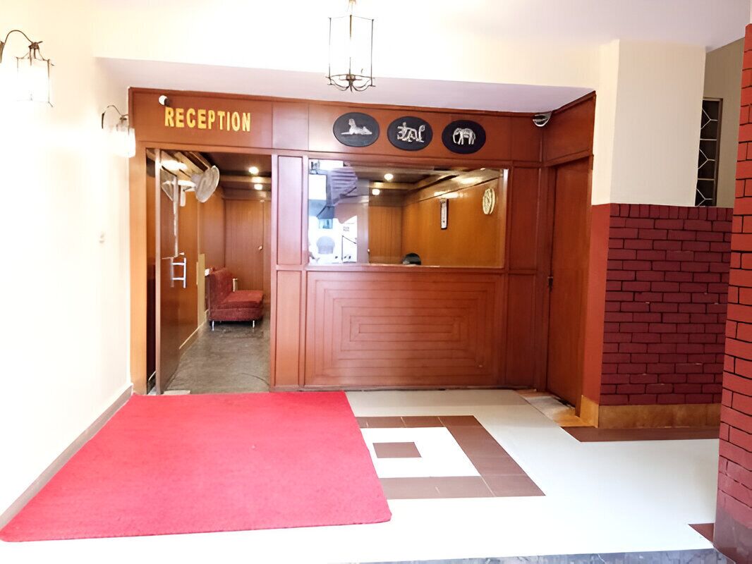 A reception area with a red carpet, wooden reception desk, and a sign with animal symbols.
